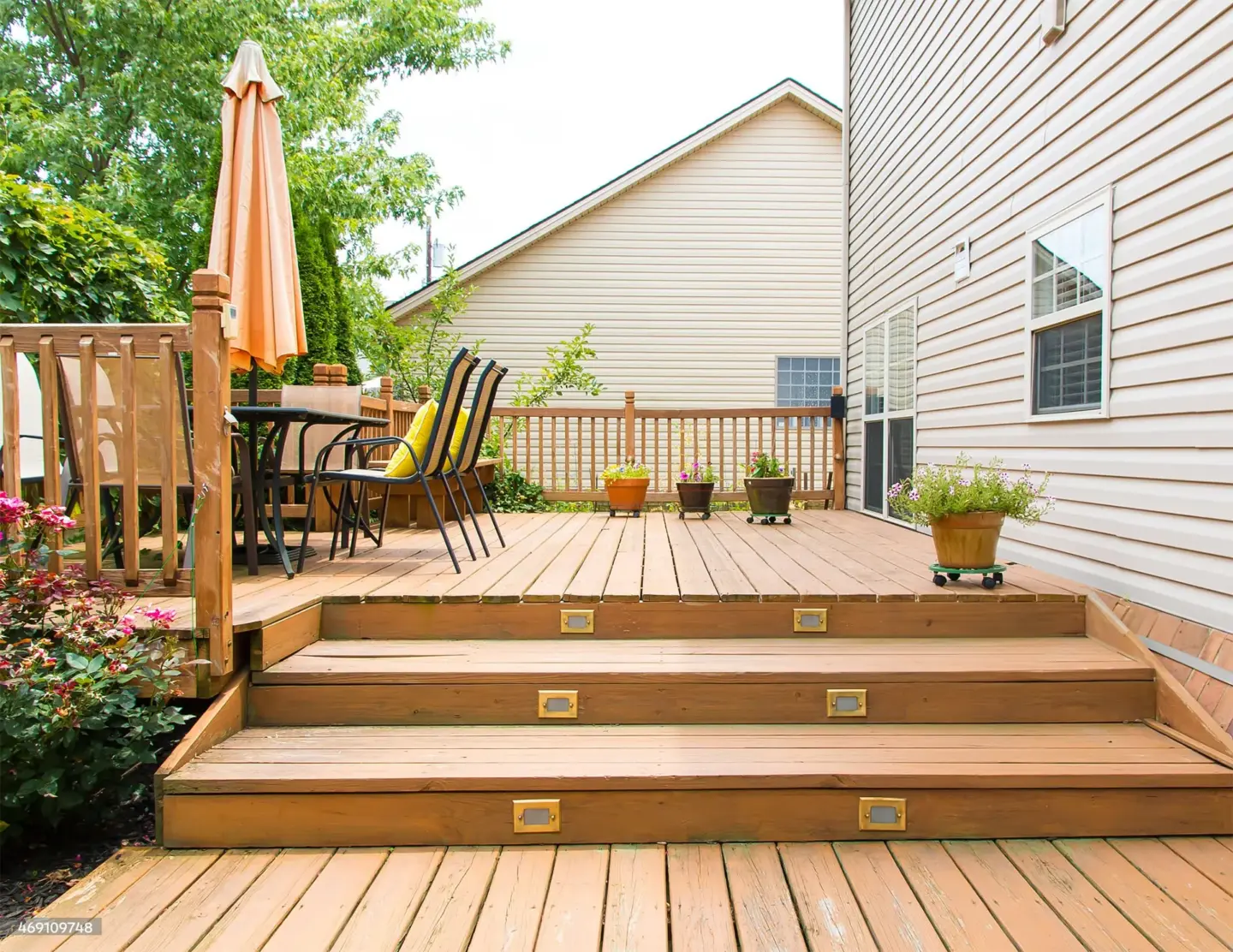 backyard-custom-deck-with-lights-on-stairs-with-outdoor-living-dining-set-area-and-potted-plants-in-southern-maryland
