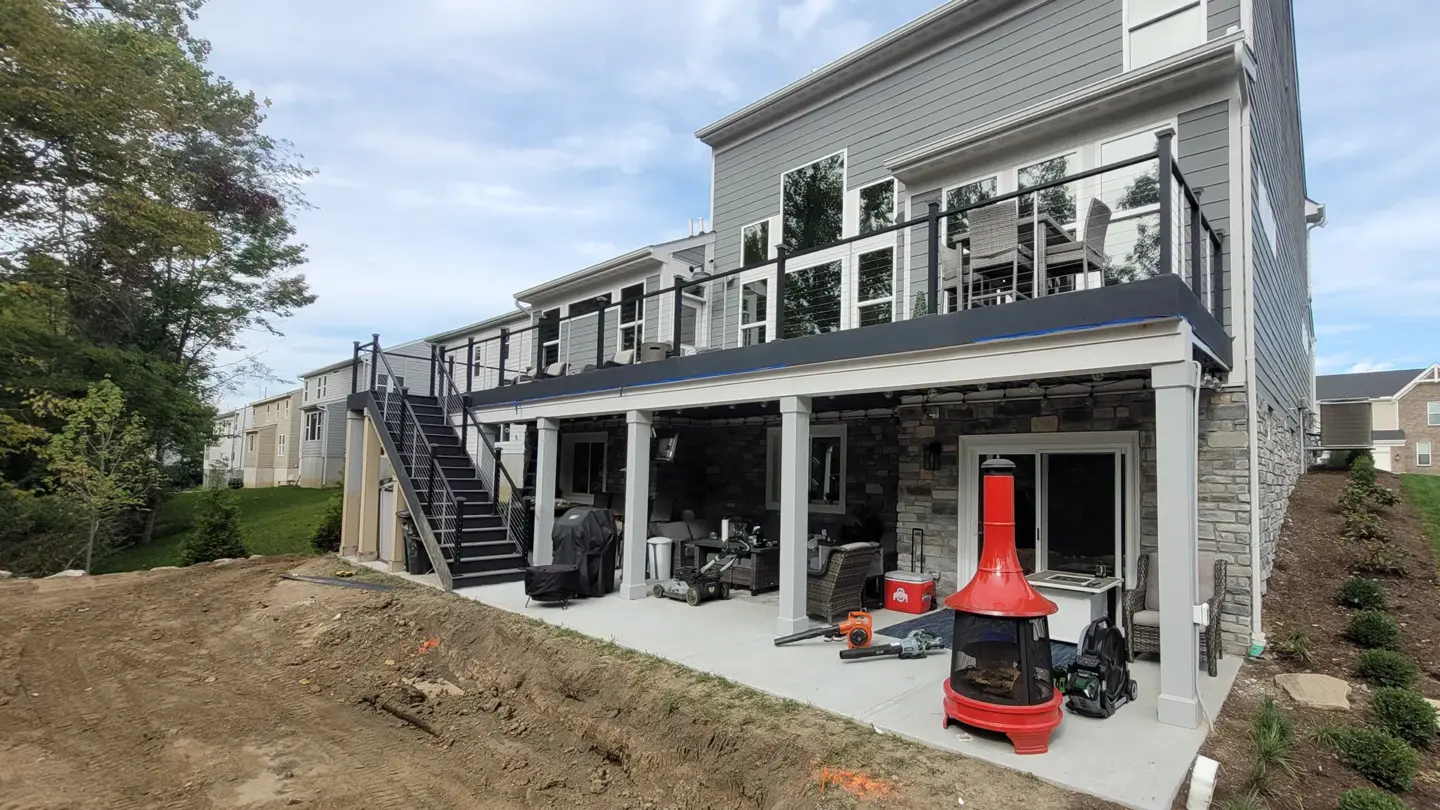 elevated-modern-deck-with-staircase-installation-and-cable-railing-with-outdoor-living-dining-set-area-attached-on-the-gray-house-in-southern-maryland