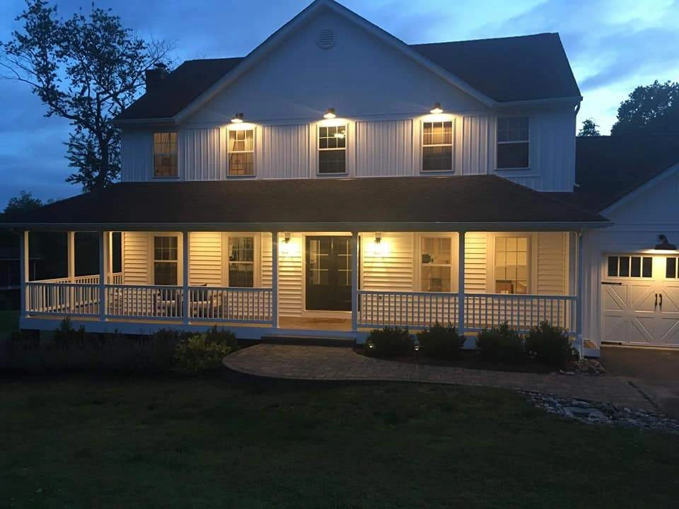 front-porch-with-white-railing-on-the-white-house-with-multiple-windows-and-white-garage-on-the-side-of-the-house-with-cloudy-sky-on-the-background-in-southern-maryland