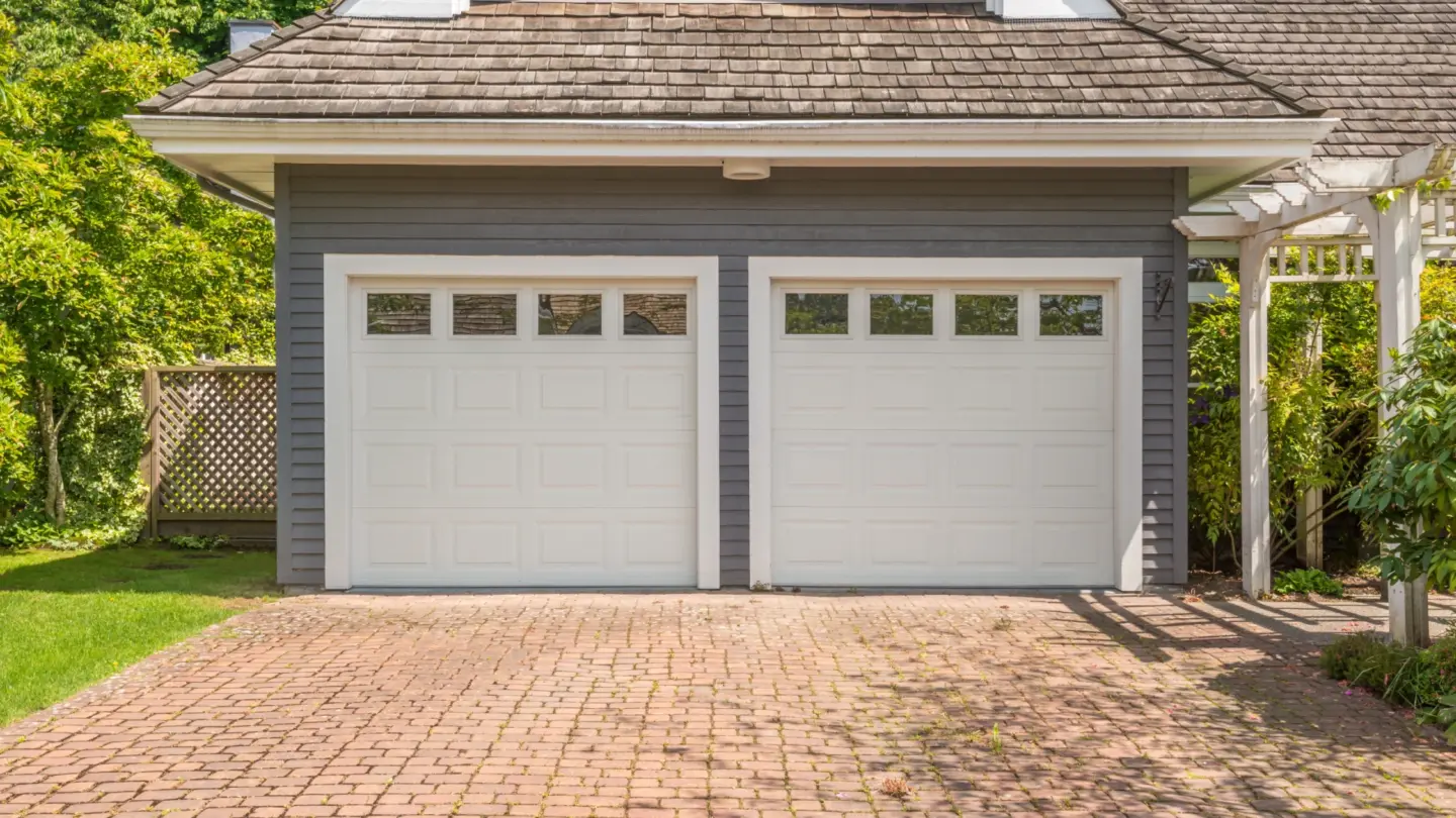 luxury-house-with-backyard-double-garage-door-with-pergola-on-the-side-and-surrounded-by-trees-and-grass-on-the-background-in-huntingtown-maryland