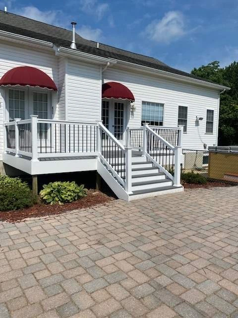 raised-deck-with-white-and-black-railing-on-the-white-house-backyard-with-multiple-windows-in-southern-maryland