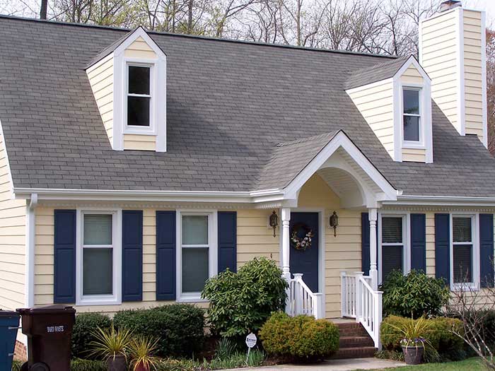 siding-replacement-on-the-residential-house-with-portico-and-white-railing-surrounded-by-grass-and-trees-on-the-background-in-huntingtown-maryland