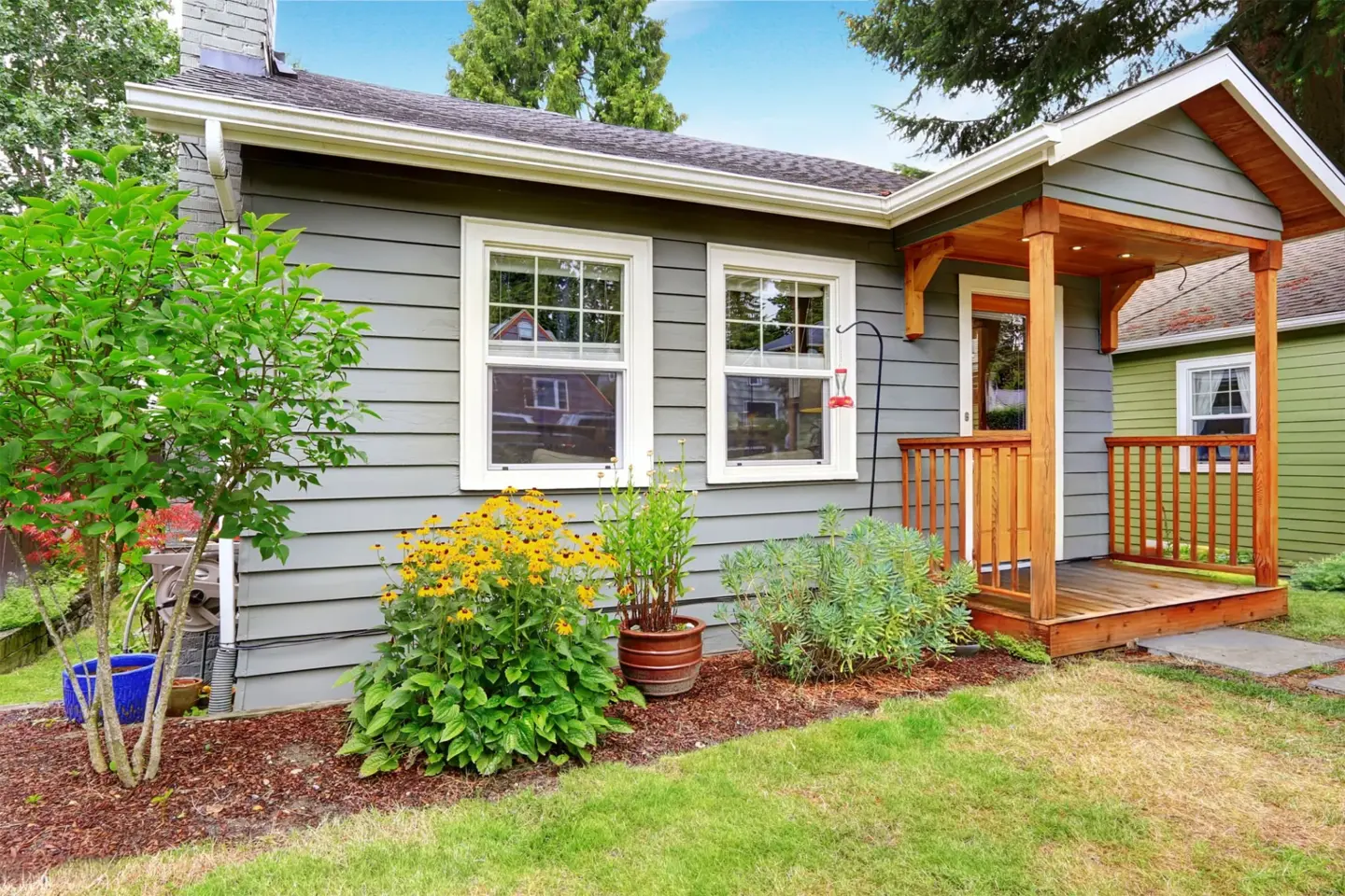small-american-house-with-gray-exterior-pain-and-porch-surrounded-by-plants-in-southern-maryland