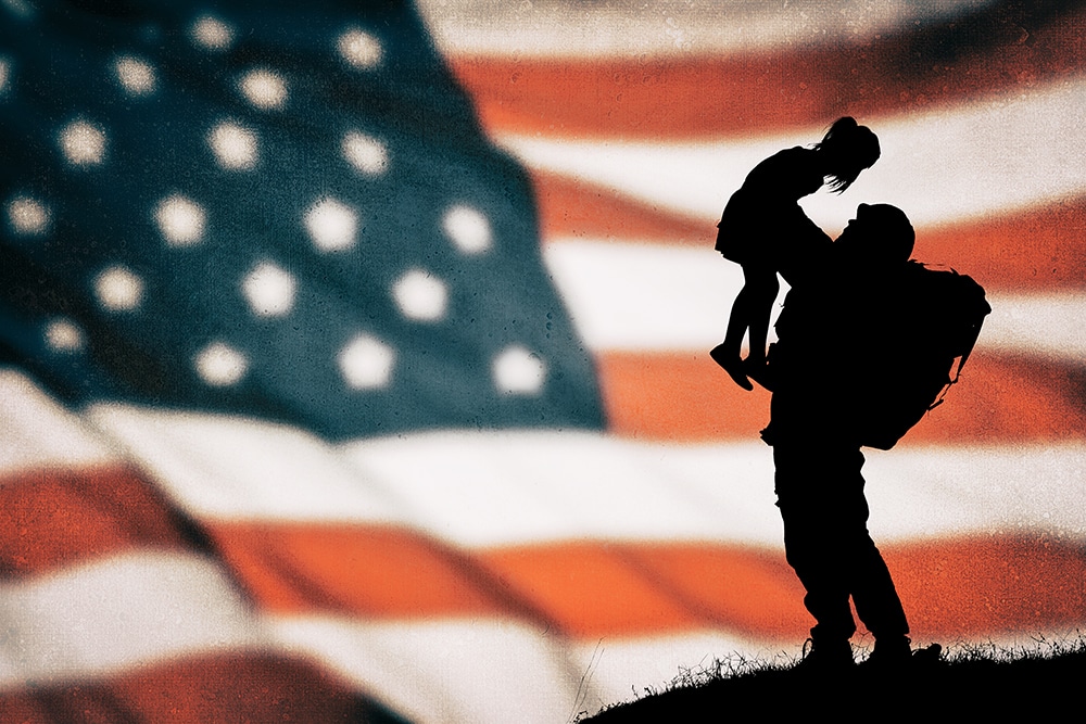 soldier-veteran-lifting-his-children-with-american-flag-on-the-background-in-southern-maryland