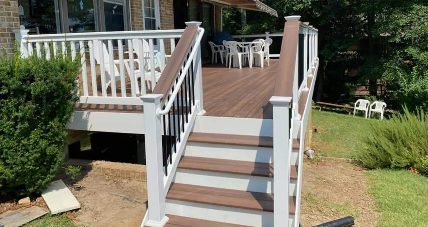 white-deck-railing-installation-on-the-raised-deck-with-outdoor-living-chairs-on-the-brick-house-surrounded-by-grass-and-tree-in-southern-maryland