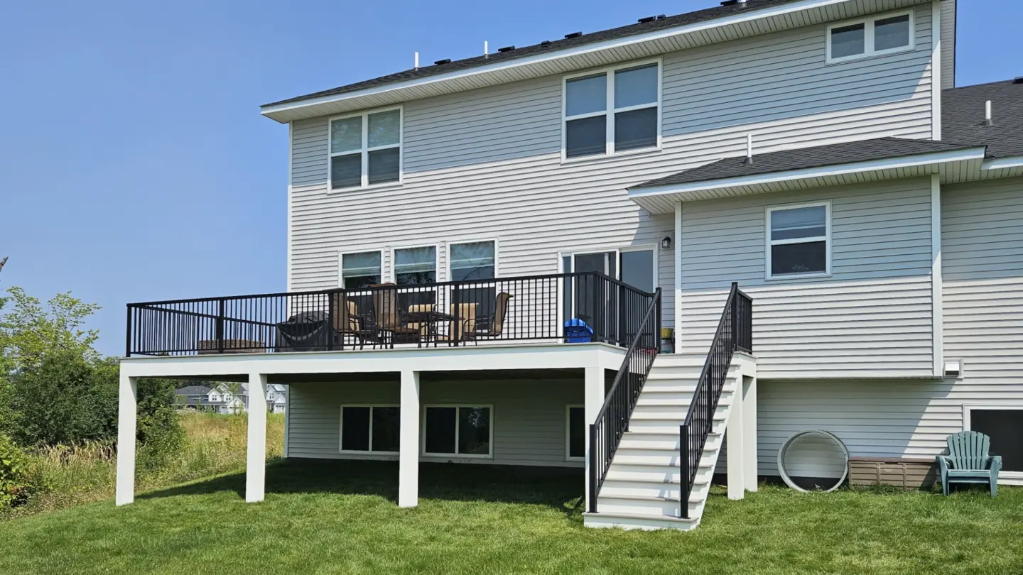 white-house-with-elevated-deck-framing-with-black-railings-on-the-backyard-and-outdoor-living-dining-set-area-in-southern-maryland