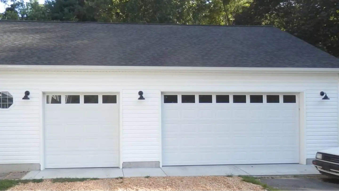 white-residential-garage-door-with-car-on-the-side-surrounded-by-big-trees-on-the-background-in-southern-maryland