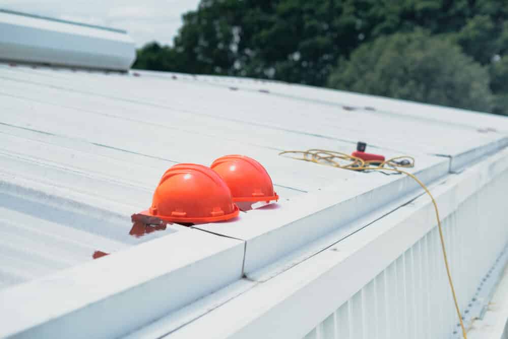 white-roof-top-gutter-installation-by-park-place-construction-with-protective-gear-and-cable-on-the-roof-in-huntingtown-maryland